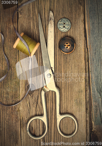 Image of vintage dressmaker scissors, bobbin of thread and buttons