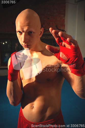 Image of Portrait of a fighter with fists in red bandages