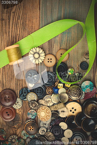 Image of vintage buttons with green ribbon and spool with thread