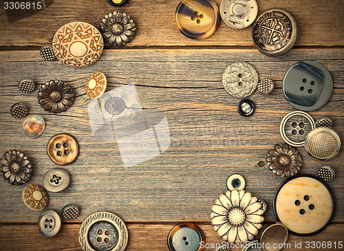 Image of several old buttons on the vintage table surface
