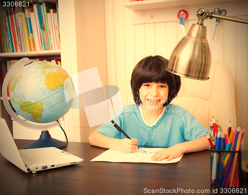 Image of smiling schoolboy doing homework