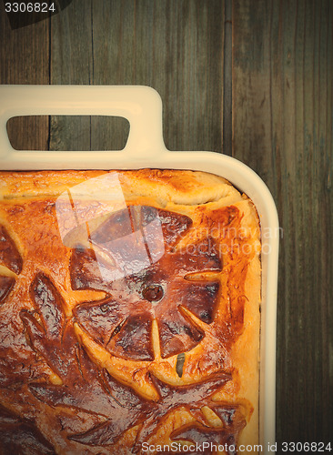 Image of pie in a white ceramic pot on vintage boards