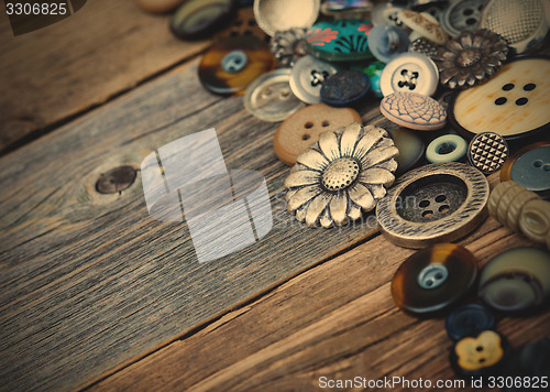 Image of buttons in large numbers scattered on aged wooden boards