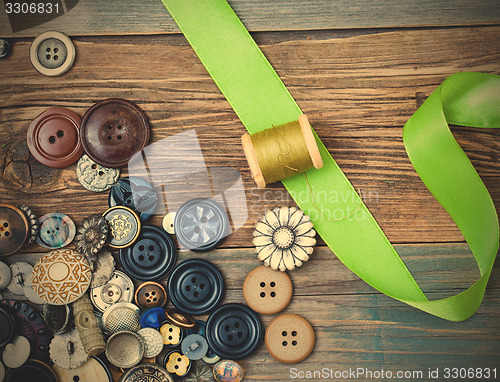 Image of spool with thread, vintage buttons and green tape