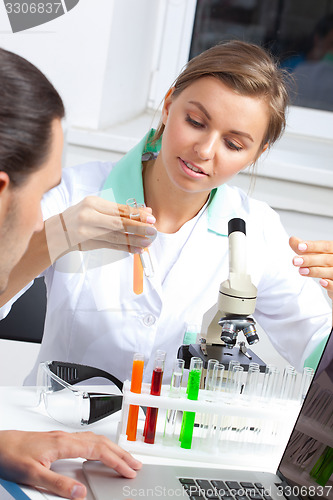 Image of female scientist looking at liquid in test tube