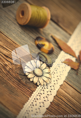 Image of button, lace tape and reel of thread