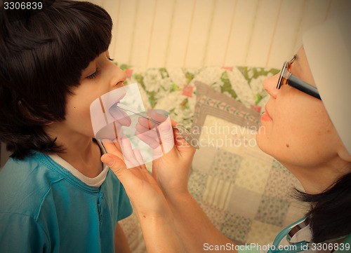 Image of boy showing his throat to doctor