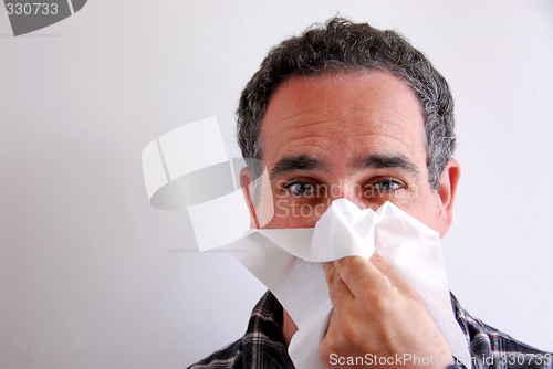 Image of Sick man blowing nose