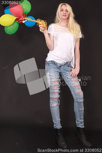 Image of Young woman with aerial balloons in the hand