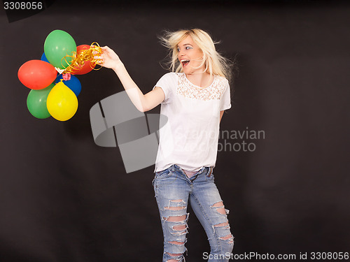 Image of Young laughing woman with coloured aerial balloons