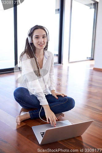 Image of relaxed young woman at home working on laptop computer