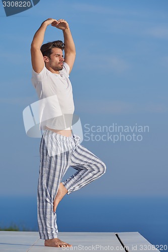 Image of young man practicing yoga