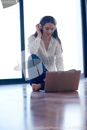 Image of relaxed young woman at home working on laptop computer