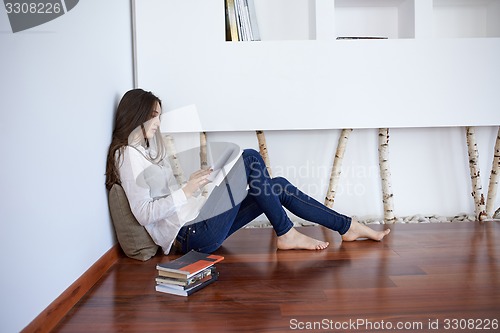 Image of relaxed young woman at home working on laptop computer