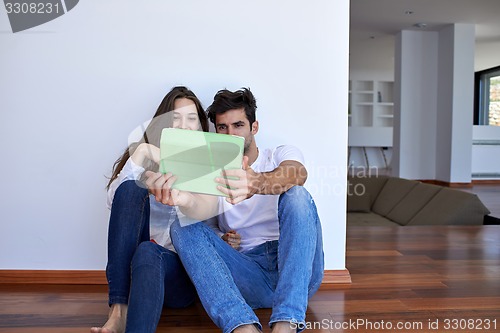 Image of couple at modern home using tablet computer