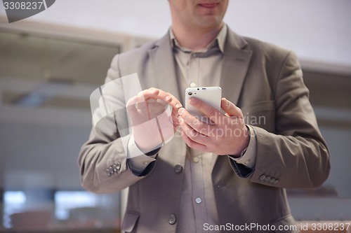 Image of business man working on phone at office