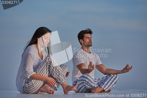 Image of young couple practicing yoga