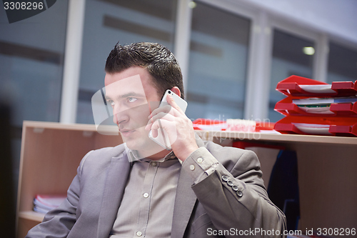 Image of business man talking by phone in office