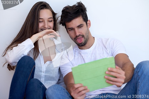Image of couple at modern home using tablet computer
