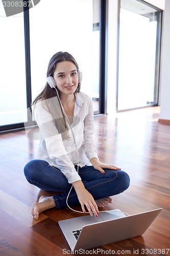 Image of relaxed young woman at home working on laptop computer