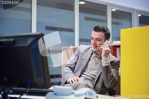 Image of business man talking by phone in office