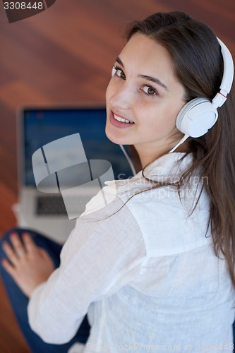 Image of relaxed young woman at home working on laptop computer