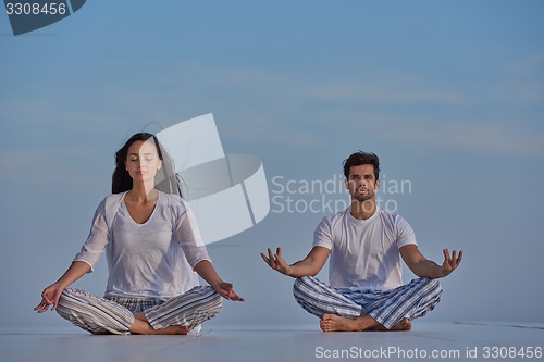 Image of young couple practicing yoga