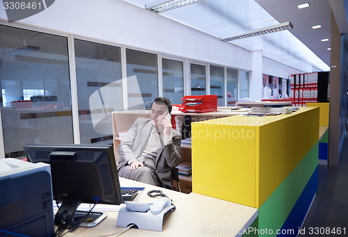 Image of business man talking by phone in office