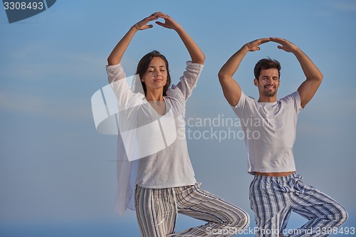 Image of young couple practicing yoga