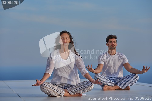 Image of young couple practicing yoga