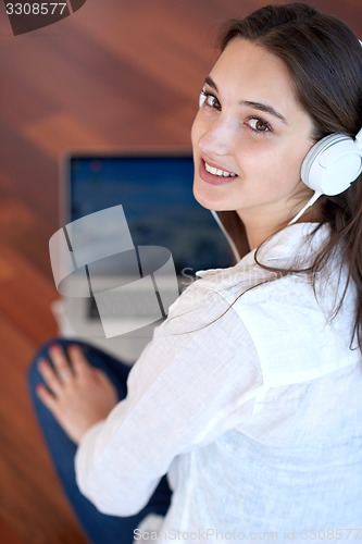 Image of relaxed young woman at home working on laptop computer