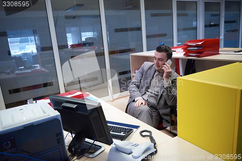 Image of business man talking by phone in office