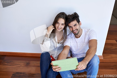 Image of couple at modern home using tablet computer