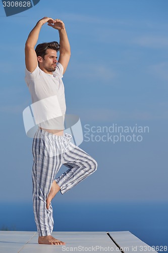 Image of young man practicing yoga