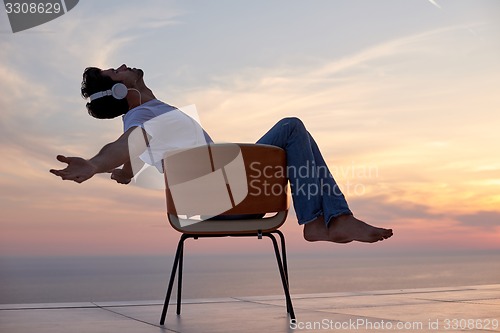 Image of relaxed young man at home on balcony