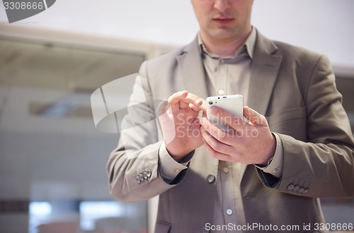 Image of business man working on phone at office