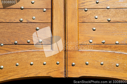 Image of caidate   varese abstract  rusty brass brown knocker in a  door 