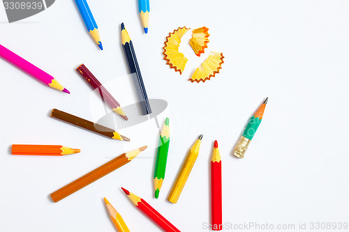 Image of several colored pencils and shavings on white background with co