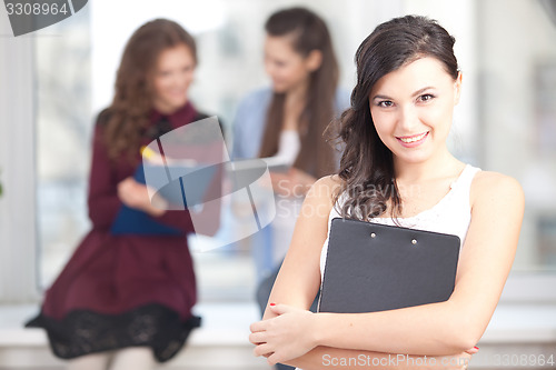 Image of smiling pretty girl looking at camera in college