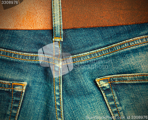 Image of vintage blue denim with seams and leather belt,  part of 