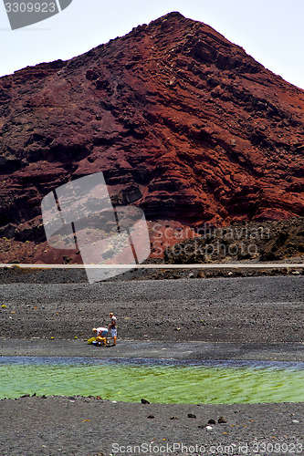 Image of people dog stone  ocean sky  water lanzarote in el golfo   