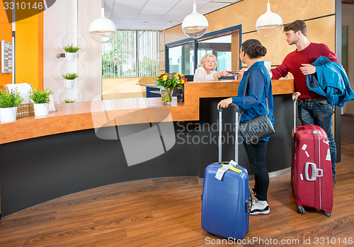 Image of young travelers at hotel check in