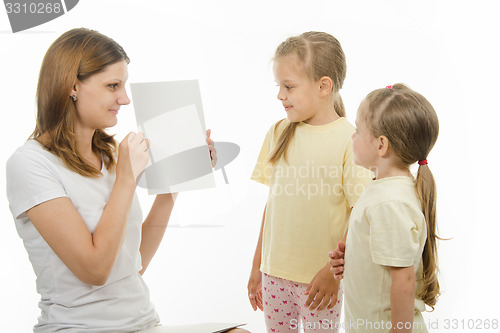 Image of Mom shows the kids a white sheet of paper