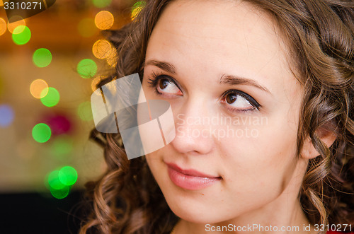 Image of Portrait a young girl on the background of Christmas lights