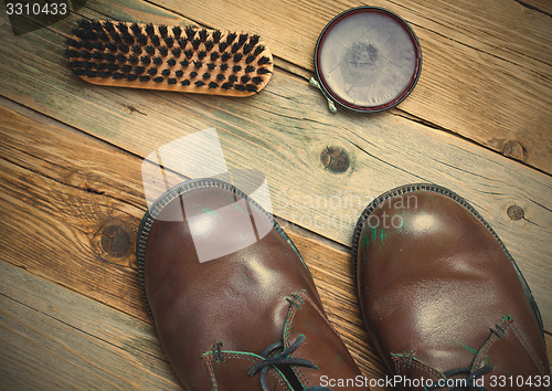 Image of Still life with brown boots, shoe polish and brush