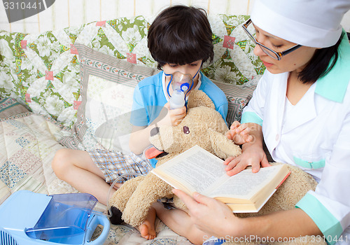 Image of doctor pediatrician spends boy inhalation session