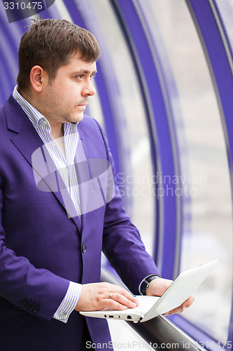 Image of businessman standing near a window