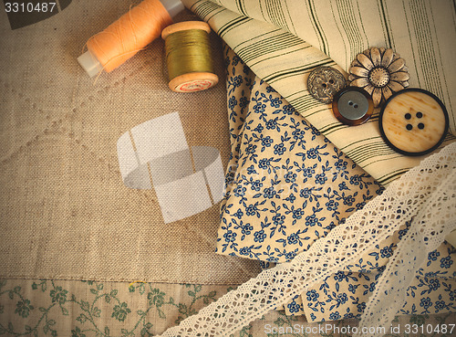 Image of fabric, thread reels, buttons and lace tapes
