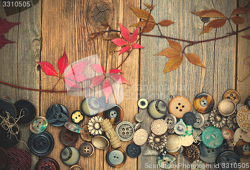 Image of vintage buttons with dried branches and red leaves