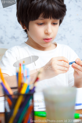 Image of boy chooses a pencil